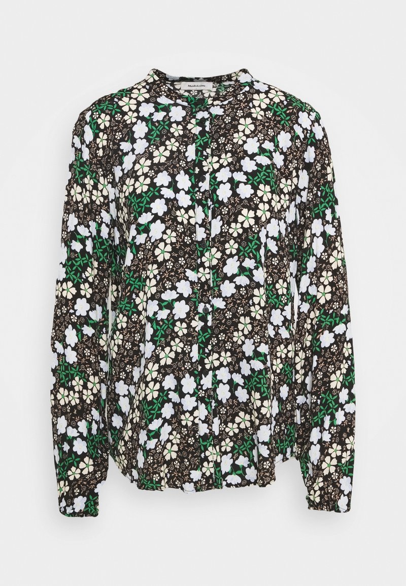 Blouse à manches longues avec fond noir et motif floral blanc, crème et vert, col rond et fermeture boutonnée à l’avant.