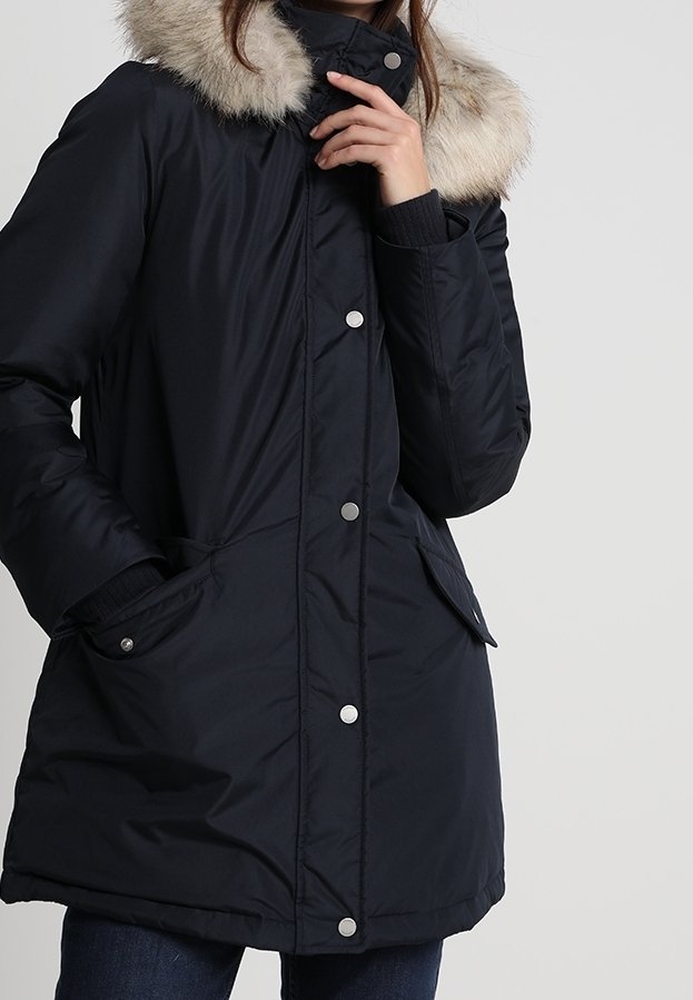 Schwarze gepolsterte Winterjacke mit einem Kragen aus Kunstfell, Druckknöpfen, Fronttaschen und gerippten Bündchen. Glatte Textur mit taillierter Silhouette.
