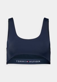 Μπλε σκούρο crop top bralette από απαλό ύφασμα, με φαρδιά ελαστική ταινία που φέρει το λογότυπο "TOMMY HILFIGER" και χωρίς μπανέλα.