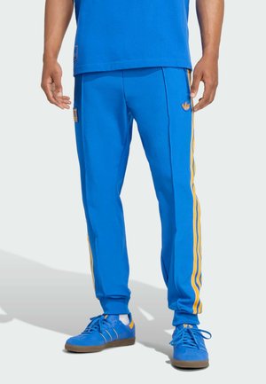 Blauwe sportbroek van een gladde stof, met gele zijkanten, een geborduurd logo en geribbelde boorden voor een strakke pasvorm.