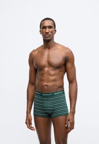 Férfi bokszerrövidnadrág sötétzöld színben, vízszintes fehér csíkokkal. Puha pamutból készült, GANT logós derékpánttal. Testhez simuló kialakítás.