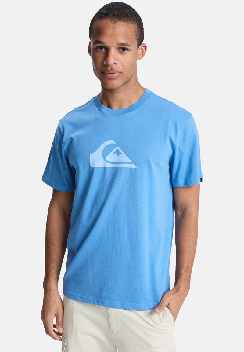 Μπλε βαμβακερό t-shirt με στρογγυλή λαιμόκοψη, κοντά μανίκια και λευκό λογότυπο στο στήθος. Μαλακή υφή και άνετη εφαρμογή.