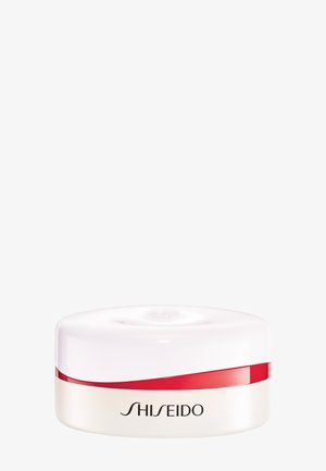 Boîte ronde blanche de crème Shiseido avec une bande rouge près du couvercle sur un fond clair uni.