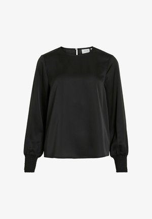 Melnas blūzes, kas izgatavota no gludas auduma, ar apaļu kakla izgriezumu, gariem piedurknēm ar elastīgām aprocēm un aizmugurējo rāvējslēdzēju.