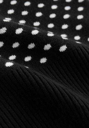 Musta neulottu kangas, jossa valkoisia pilkkuja ja kuvioitu, uritettu rakenne. Materiaali näyttää pehmeältä ja joustavalta.