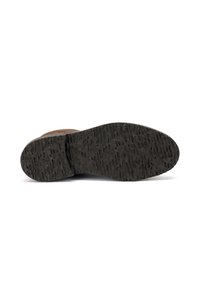 Suela de zapato de cuero texturizado marrón con una suela exterior de goma negra resistente que presenta un patrón de banda de rodadura pronunciado para mayor tracción.