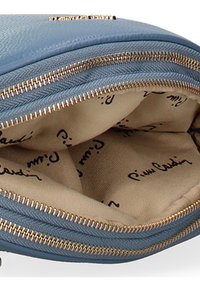 Borsa con zip di colore blu chiaro con esterno in pelle testurizzata. L'interno presenta una fodera beige stampata con testo corsivo nero e accessori in tonalità oro.