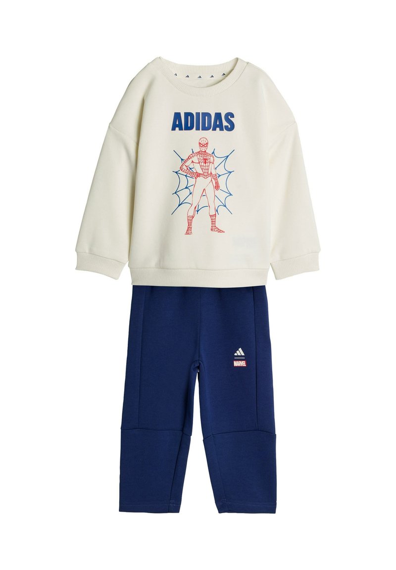 Krémová mikina s modrým nápisom „ADIDAS“ a červenou grafikou Spider-Mana, kombinovaná s tmavomodrými nohavicami s logami Adidas a Marvel.