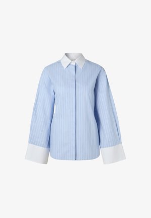 Heled sinine nööpidega särk vertikaalsete valgete triipudega, klassikaline krae ja laiad valged mansetid. Sile tekstuur ja struktureeritud istuvus.