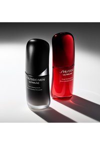 Svart og rød flaske serum med avrundede topper, med glansfulle overflater og etiketter. Den svarte flasken har etikett "Shiseido Men Ultimune," den røde flasken har etikett "Shiseido Ultimune."