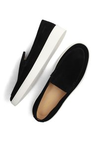 Zwarte suède instappers met dikke witte rubberen zolen, gestikte bovenkant en tan lederen binnenzolen, weergegeven vanuit boven- en zijaanzicht.