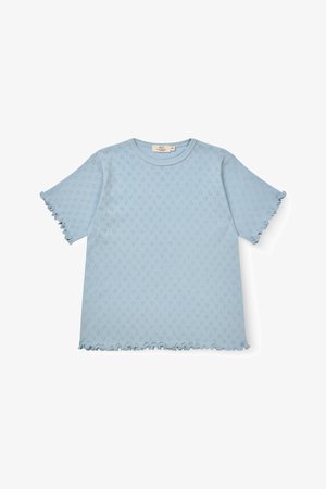 Svetlomodrý krátky pletený top s malým diamantovým očkovým vzorom a volánikovými okrajmi na rukávoch a leme, položený na bielom pozadí.