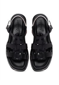 Black sandals with multiple wide straps, a textured matte finish, and adjustable buckle. Flat sole with a smooth interior lining.