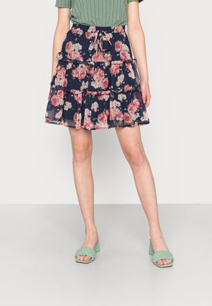 Bloemrijke tiered rok met een marineblauwe achtergrond, voorzien van roze en rode bloemen. De rok heeft een trekkoord taille en is gemaakt van zachte, lichtgewicht stof.