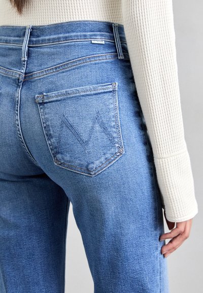 Light blue denim jeans with a straight fit, featuring a triangular stitch design on the back pocket and a subtle faded texture.
