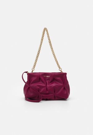 Bolso de cuero rosa oscuro suave y plisado con cadena dorada como correa y pequeño logo en la parte delantera, aislado sobre fondo blanco.