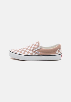 Baskets slip-on avec un motif à carreaux beige et blanc, tige en daim et semelle en caoutchouc, présentant une bande noire et un détail du logo Vans.