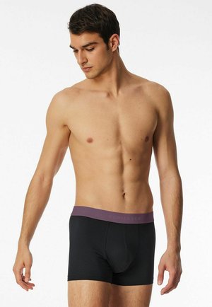 Black boxer briefs with a dark purple elastic waistband featuring the brand name. The material appears smooth and stretchy.