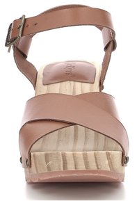 Sandalo in pelle marrone con cinturini incrociati e una piattaforma in legno. Presenta una fibbia e una superficie liscia in legno naturale sulla suola.