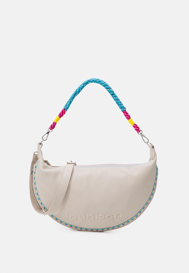 Sac à main beige en forme de croissant avec une poignée tressée bleue, rose et jaune et une bordure colorée le long du bord courbé.