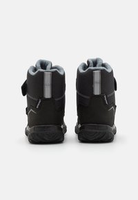 Bottes montantes noires en matériau synthétique avec une doublure grise douce, une sangle ajustable et une semelle en caoutchouc texturé pour une meilleure adhérence.
