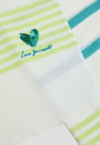 Écharpe légère avec des rayures vertes et blanches, ornée d'un cœur en sequins teal et de l'inscription brodée "Aime-toi" en fil assorti. Bords frangés.