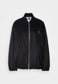 Musta bomber-takki, joka on valmistettu sileästä kankaasta. Takissa on vetoketjulukko, ribbauskaulus, sivutaskut ja pieni brodeerattu logo rinnassa.