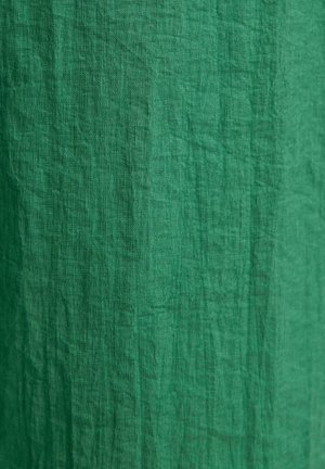 Zeleni platneni materijal s naboranom teksturom, s suptilnim varijacijama u nijansama. Nema uzoraka ni metalnih dijelova.