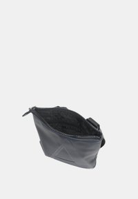 Borsa a tracolla nera con texture, chiusura a zip e forma angolata. L'interno presenta una fodera con logo. Include una tracolla regolabile.