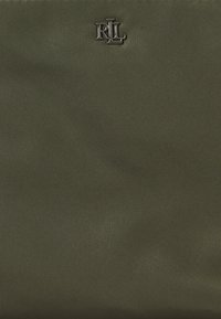 Tecido texturizado verde escuro com um brilho subtil, apresentando um logótipo metálico no canto superior esquerdo, exibindo um design minimalista.