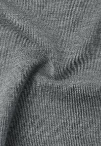 Szara dziana tkanina o teksturowanym, prążkowanym wzorze pokazuje drobne pętelki. Materiał wydaje się miękki i elastyczny, odpowiedni do odzieży lub akcesoriów.