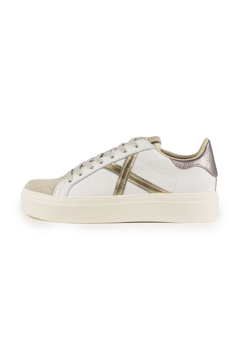 Sneaker bianco con punta in suede, dettagli metallici dorati, finitura testurizzata e un tab sul tallone lucido a contrasto.