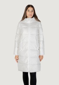 Giacca puffer bianca con zip frontale, cappuccio e due tasche laterali. Il tessuto è lucido e trapuntato con una texture morbida. Maniche lunghe.