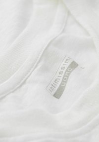 Weißes Baumwoll-T-Shirt mit strukturiertem Finish, versehen mit einem grauen Stoffetikett, das "Intimissimi Uomo" am Ausschnitt zeigt.