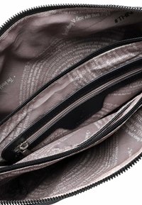 Portafoglio nero con zip, con una superficie liscia, multiple scomparti e una fodera decorata con testi in colori chiari.