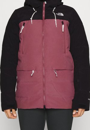 Tweekleurig jack met zwarte mouwen en capuchon, donkerroze lijf, voorrits, vier zakken met rits en witte trekkoorden, gedragen door een persoon.