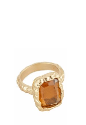 Gold-tone ring with a large, rectangular amber-colored faceted stone set in a textured, uneven bezel.