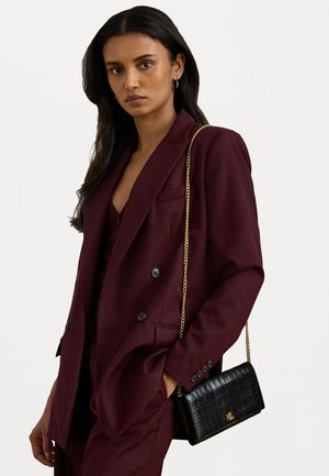 Μπορντό διπλό αμπίρ σακάκι, υφασματοποιημένο, με μια μαύρη ψεύτικη κροκοδείλια τσάντα χιαστί που διαθέτει χρυσό αλυσίδα και λογότυπο.