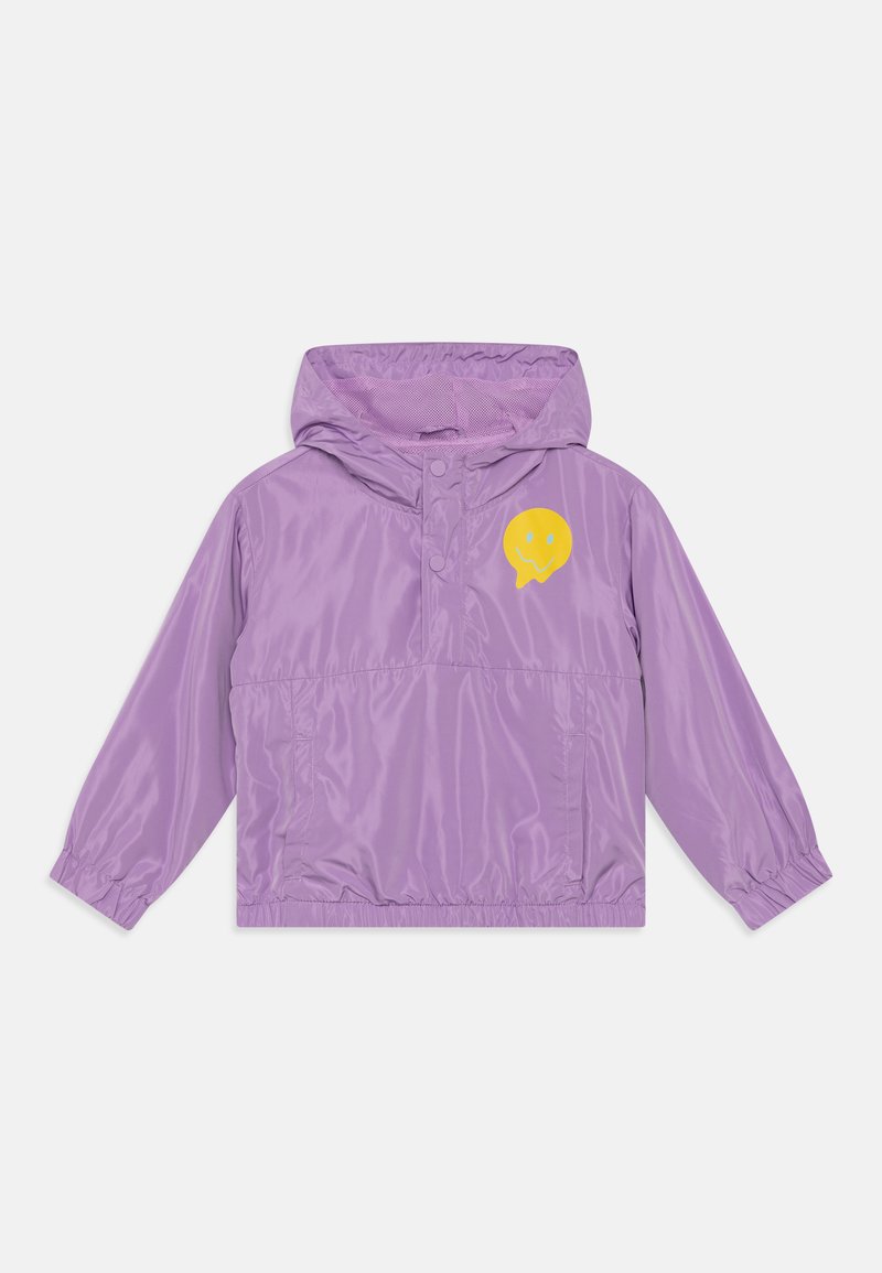 Casaco corta-vento roxo com capuz, apresentando um logótipo de smiley amarelo no peito e punhos elásticos nas mangas. Material leve.