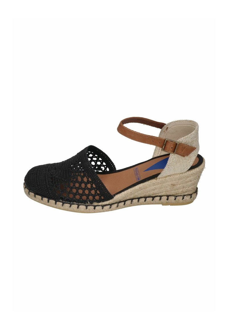 Espadrilles negras trenzadas con cuña y correa al tobillo, suela de cuerda natural y parte trasera de lienzo beige. Diseño de punta abierta y detalles de tela texturizada.