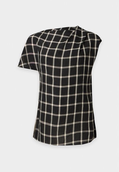 Blouse noire à manches courtes avec motif en grille blanche et encolure asymétrique, présentée à plat sur un fond clair.