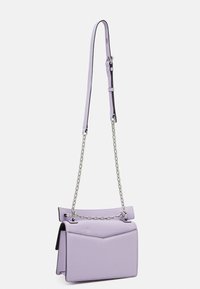 Fialová kožená kabelka se strukturovaným tvarem, s popruhem přes rameno s řetízkovým zdobením a kontrastním černým vnitřkem.