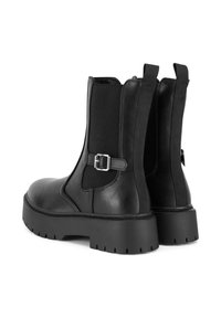Botines de cuero negro con paneles laterales elásticos, una correa con hebilla y una suela gruesa de goma con patrones de tracción.