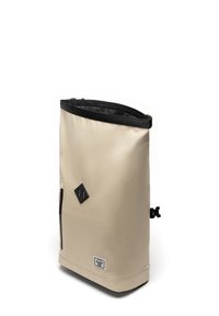 Beige waterproof backpack with a roll-top design, black accents, side zipper pocket, and a diamond-shaped logo patch at the front.