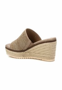 Sandalia cuña de tela beige con textura tejida. Cuenta con una suela alta envuelta en yute y una planta acolchada para mayor comodidad. Diseño de punta abierta.