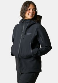 Musta vedenpitävä takki vetoketjulla edessä, säädettävällä hupulla ja vetoketjullisilla taskuilla. Rintakehässä logo ja teksturoitu kangas.