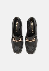 Mocassins en cuir noir avec détail en métal doré en forme de mors de cheval, bout carré, avec la taille 37 imprimée à l'intérieur.