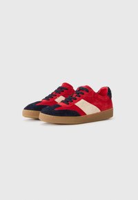 Røde og marineblå semskede sneakers med kremfargede detaljer, teksturert gummisåle, flate lisser og kontrasterende stoffdetaljer på tåen og hælen.