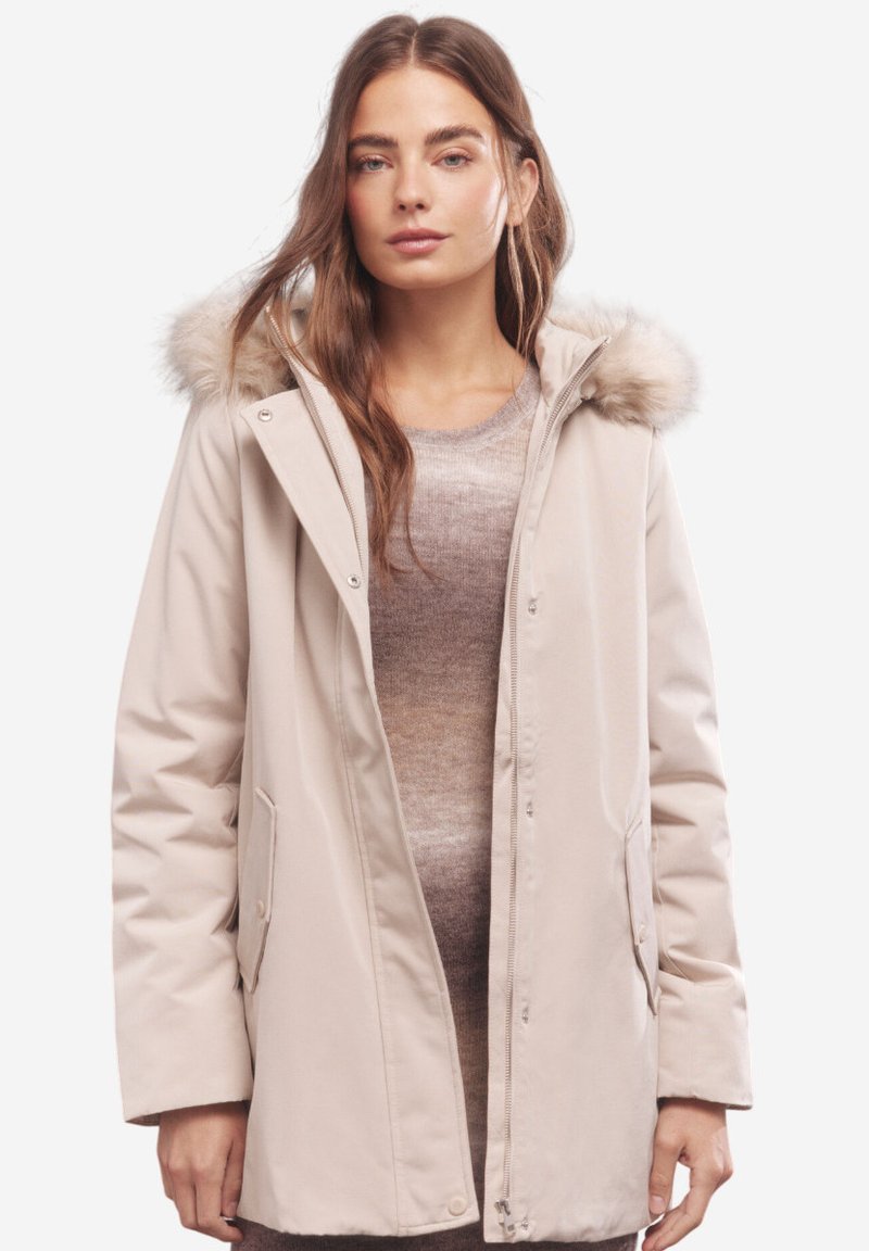 Parka beige con cappuccio in pelliccia sintetica, chiusure a zip e a pressione, tasche laterali e un materiale esterno liscio e resistente all'acqua. Design classico e funzionale.