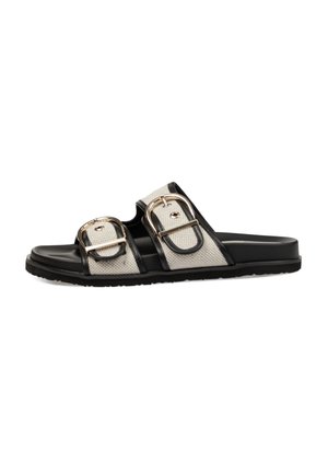 Sandalia negra de pala con dos tiras de tela beige con grandes hebillas plateadas y una suela negra.